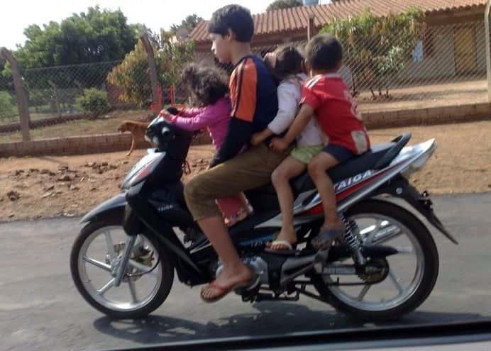 Menores juegan carreras en motos