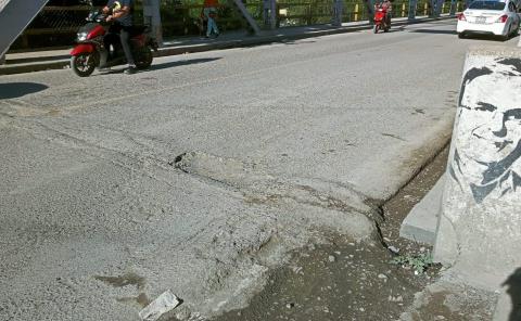 Prominente bache en el puente metálico
