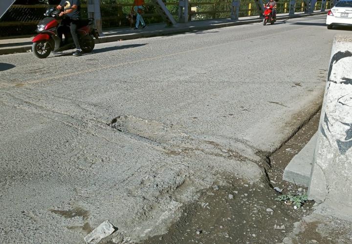 Prominente bache en el puente metálico